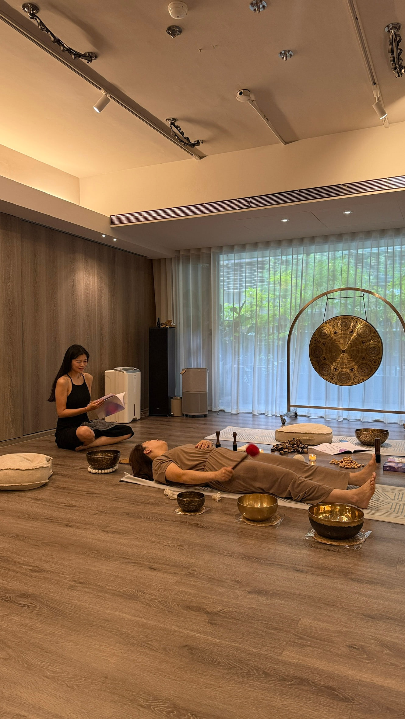 學員躺下感受頌缽振動，Bowa 在旁引導