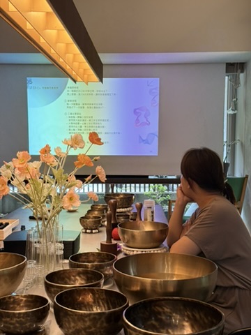 Bowa 在頌缽與投影教材前進行自我療癒教學